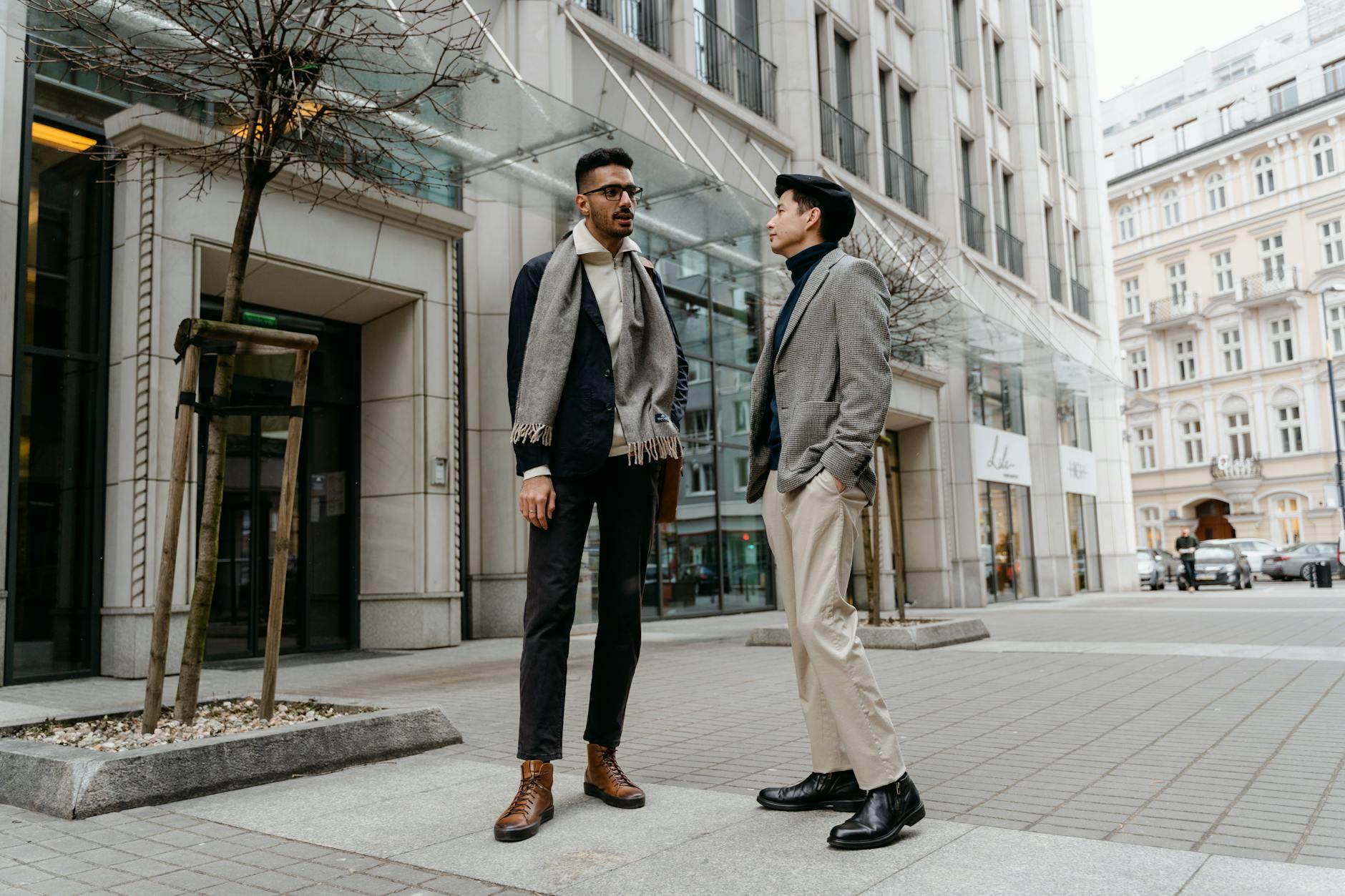 Nowoczesny dress code biznes casual dla mężczyzn: od garnituru do chinosów Dwóch eleganckich mężczyzn w stylu business casual w miejskiej scenerii